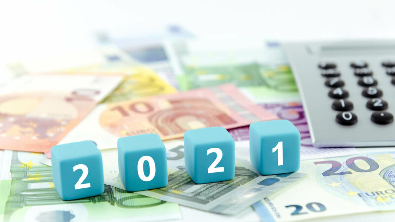 Geldscheine, Taschenrechner und Würfel mit Zahlen 2021